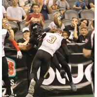 An Arizona Rattlers receiver is tackled into the boards by a member of the Iowa Barnstormers
