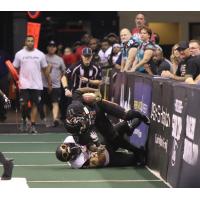 Dezmon Epps of the Arizona Rattlers is tackled along the boards by a member of the Iowa Barnstormers