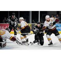 Nick Lappin of the San Antonio Rampage (in black) battles for a puck in front of the Chicago Wolves net
