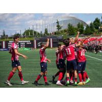 Atlético Ottawa players celebrate the opening goal in front of a packed TD Place