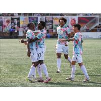 Abou Sissoko and Ballou Tabla celebrate after combining for a record-breaking Atlético Ottawa goal